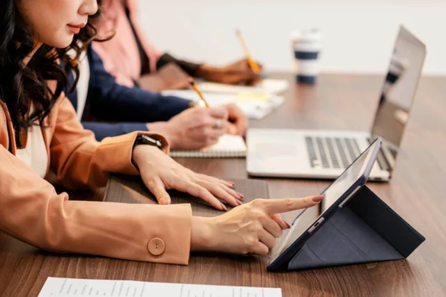 People working on laptops together at a shared table